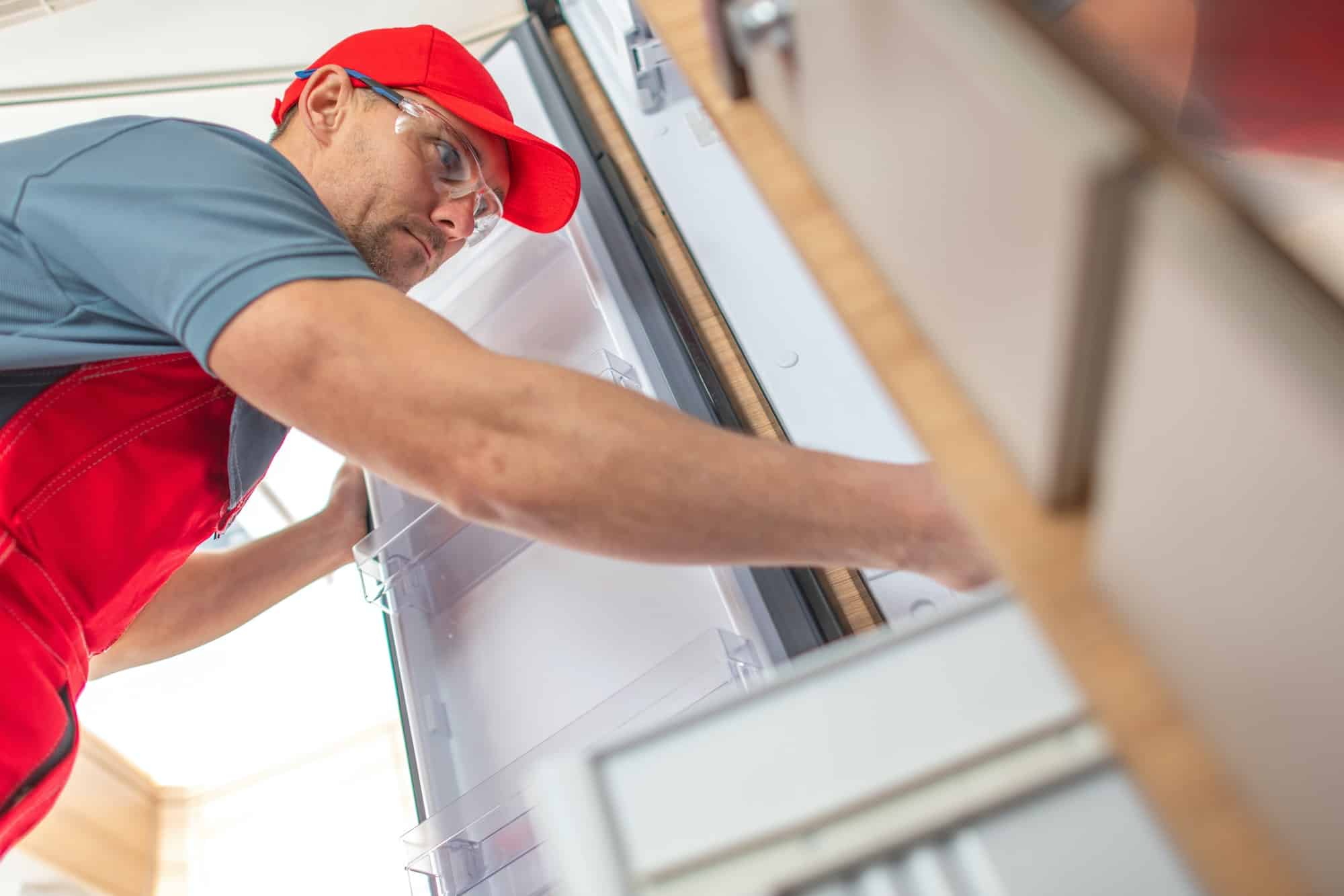 RV Technician Looking Inside Camper Refrigerator