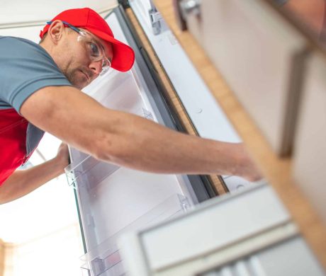 RV Technician Looking Inside Camper Refrigerator